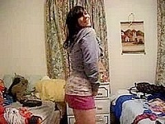 Busty brunette stripping in bedroom