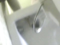 A bikini wearing girl is pissing in beach toilet